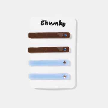 Four brown and blue hair slides with rhinestones on a white packaging.