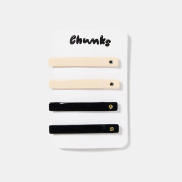 Cream white and black hair slides with rhinestones on a white packaging