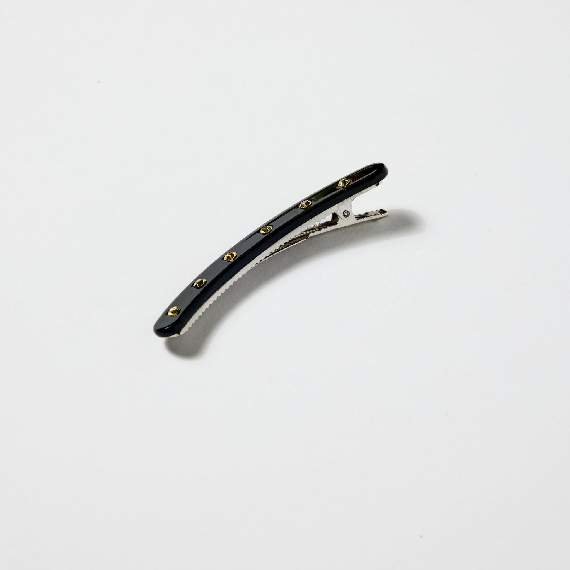 Black clip with white rhinestones on a white background