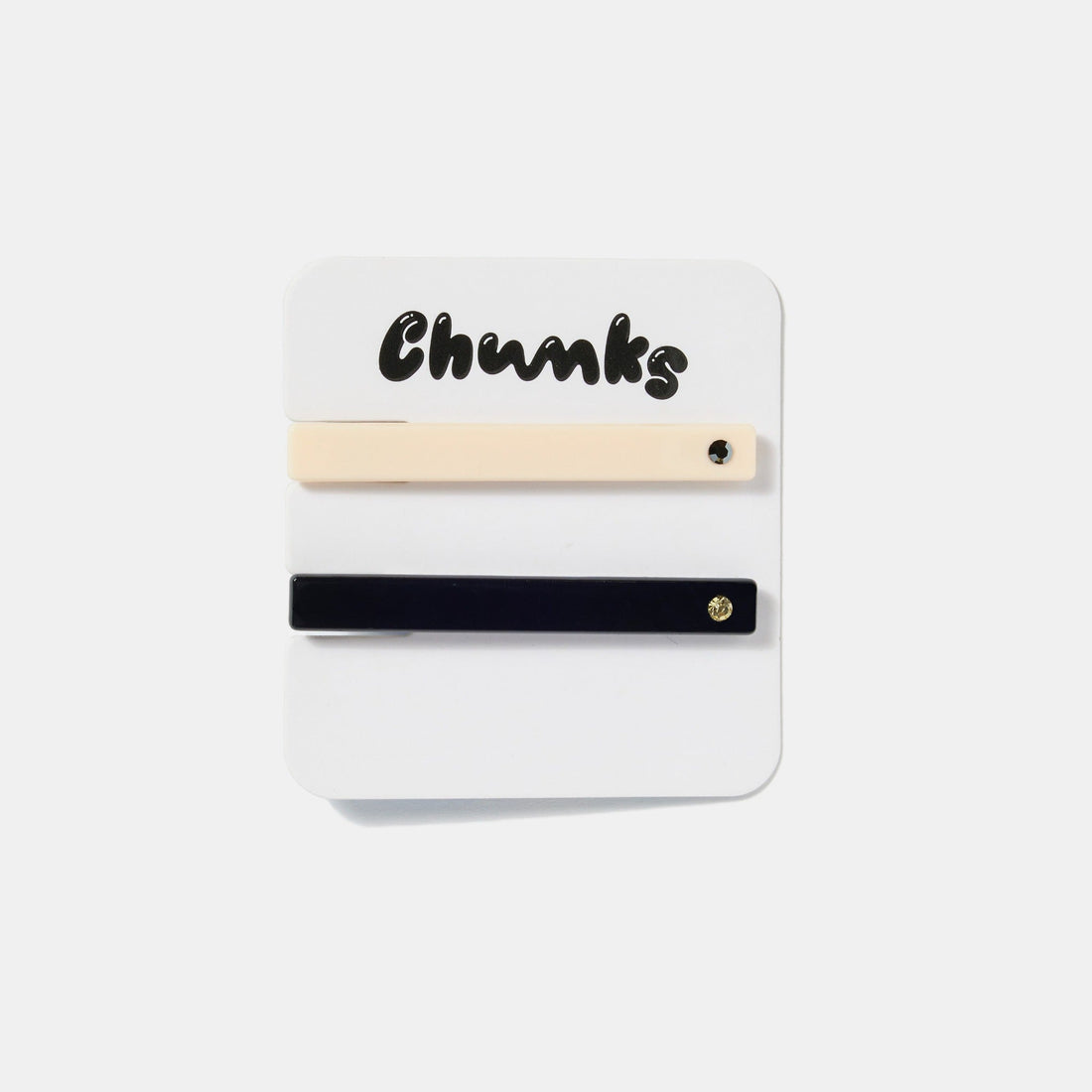 Cream white clip with black rhinestone, and black clip with gold rhinestone on a white packaging