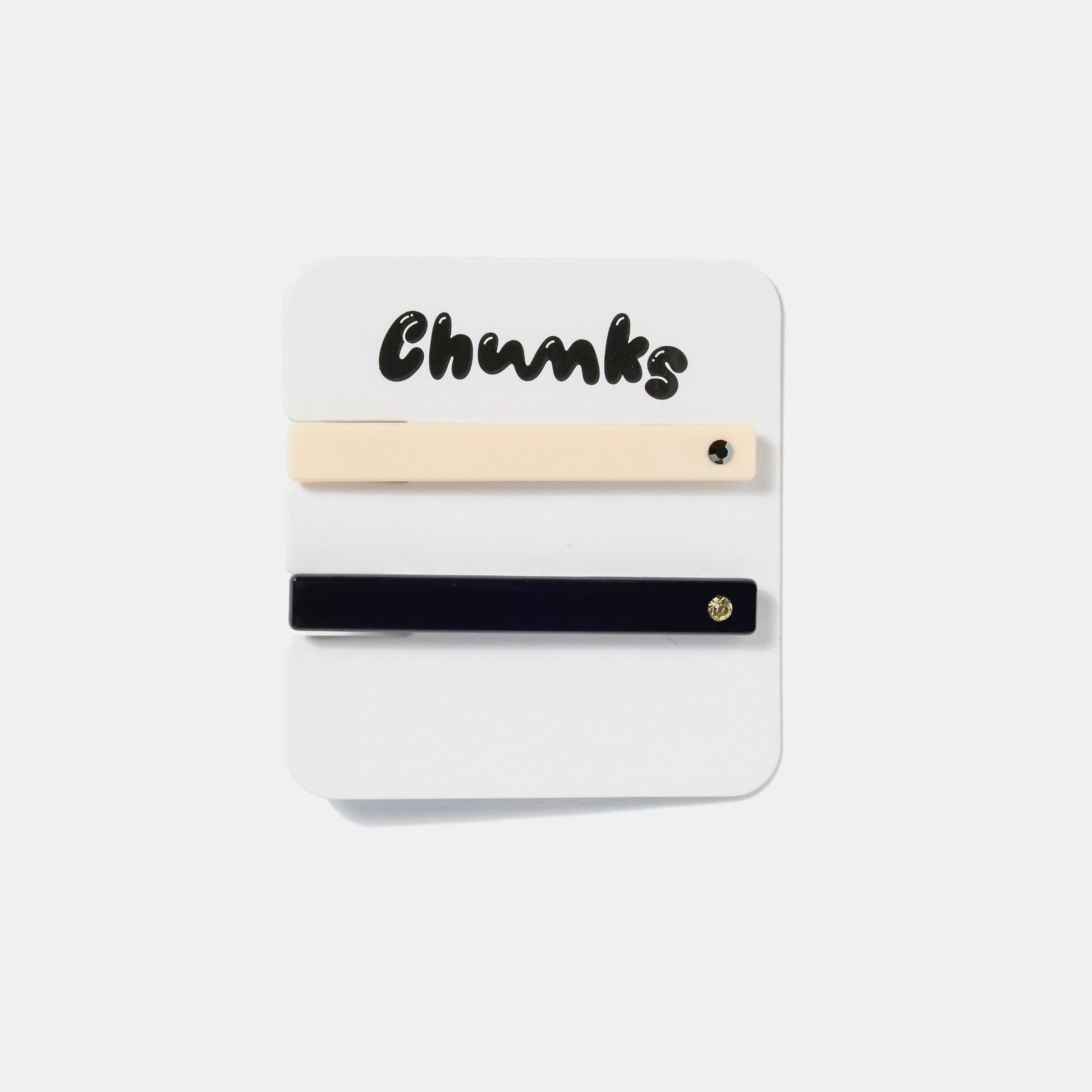 Cream white clip with black rhinestone, and black clip with gold rhinestone on a white packaging