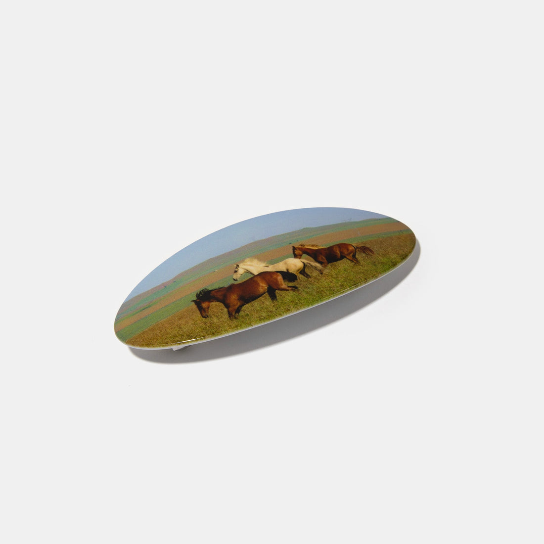 Hair barrette with printed horses on a white background