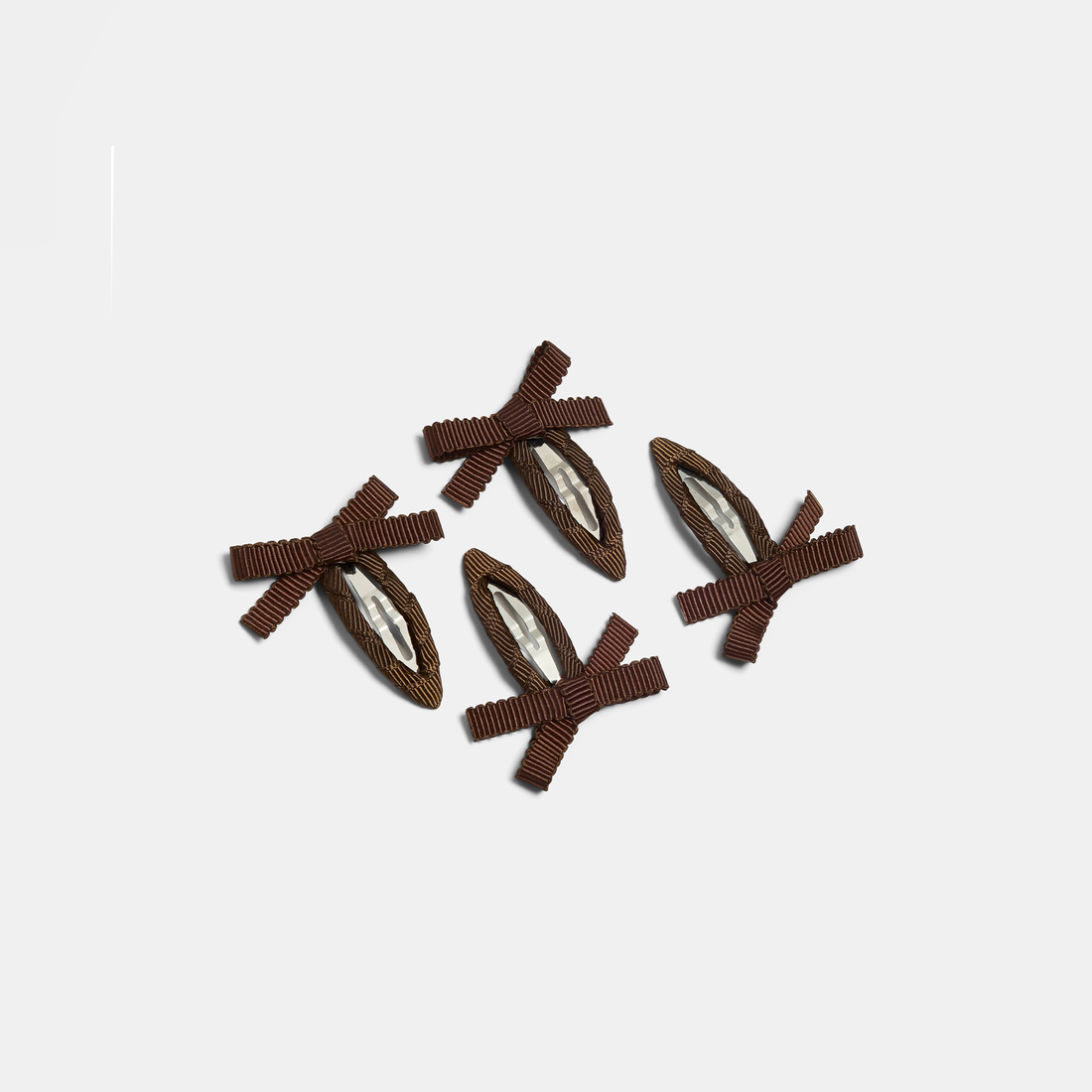 Four brown bow snap hair clips on a white background.