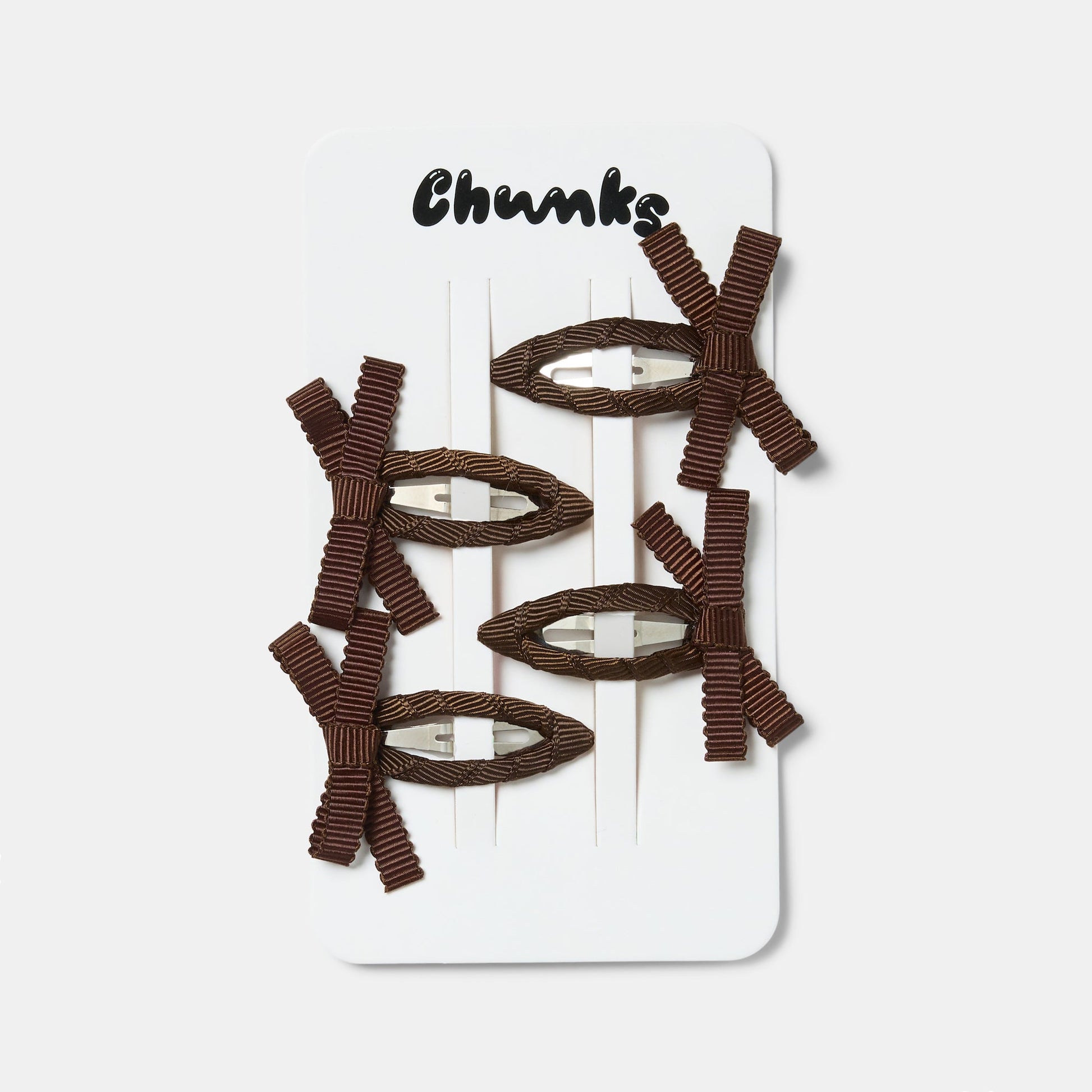 Four brown bow snap hairclips clipped on a white packaging.