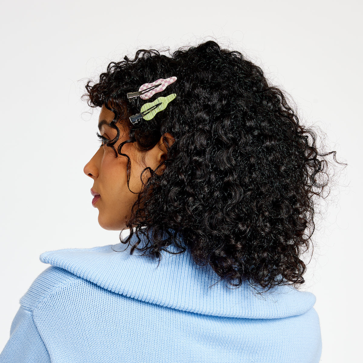 Woman with black curly hair wearing two setting clips