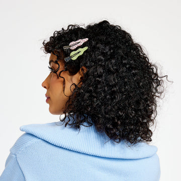Woman with black curly hair wearing two setting clips