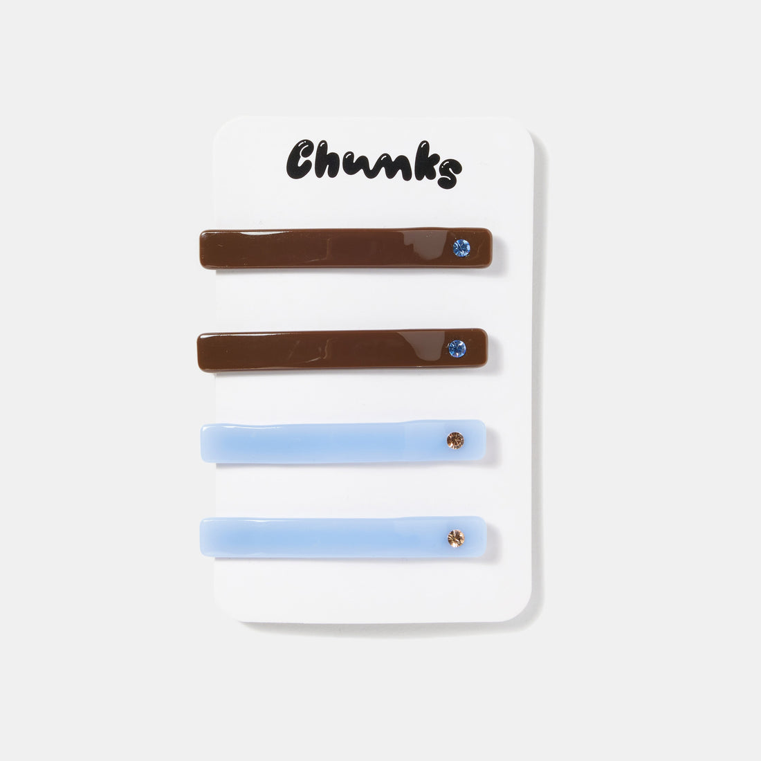 Four brown and blue hair slides with rhinestones on a white packaging.