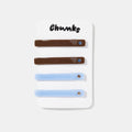Four brown and blue hair slides with rhinestones on a white packaging.
