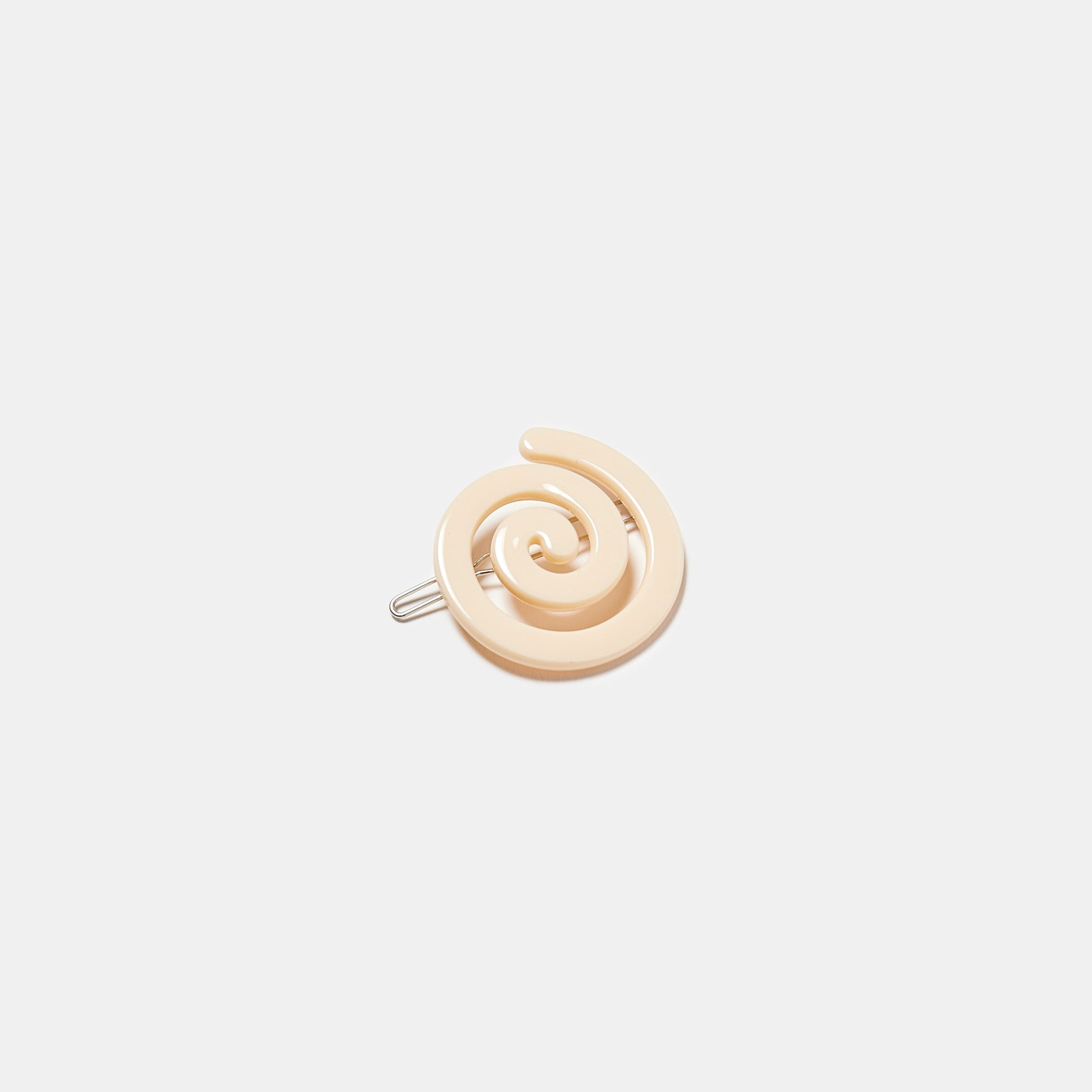 Cream white hair clip with spiral pattern on a white background
