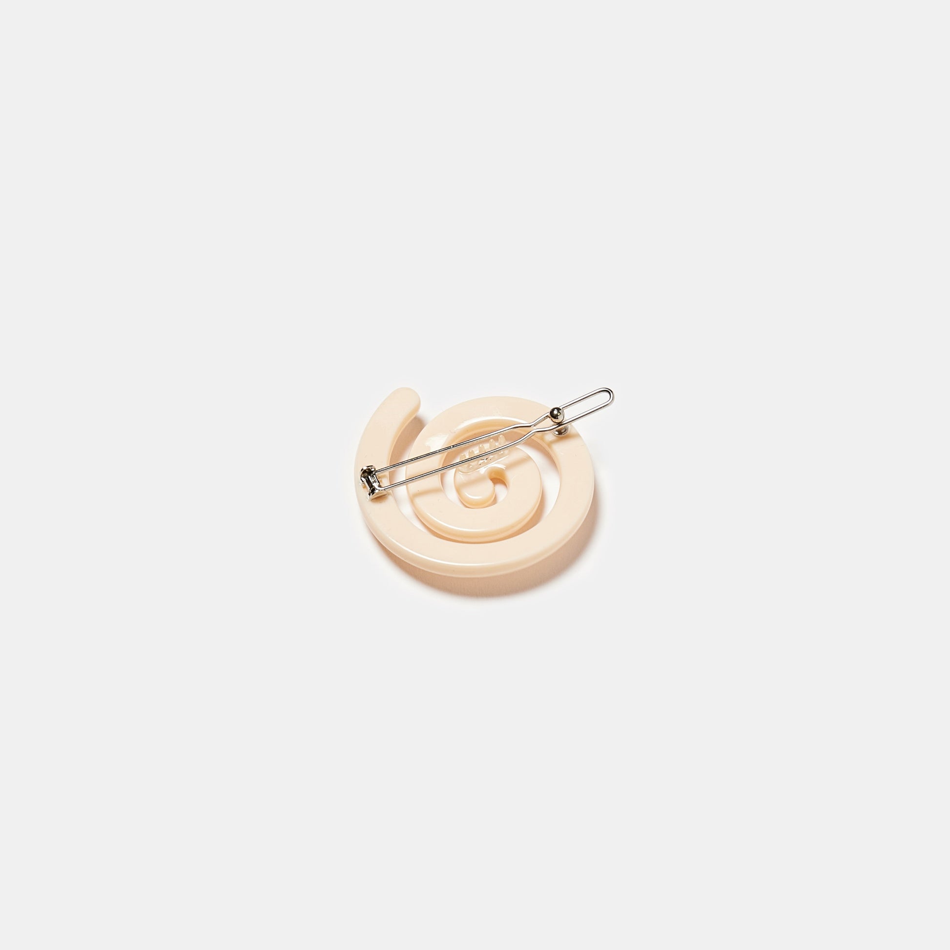 Cream white hair clip with spiral pattern on a white background