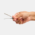 Hand unclasping a white hair clip on a white background