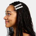 Woman with black braids wearing two white hairclips with printed ants design.
