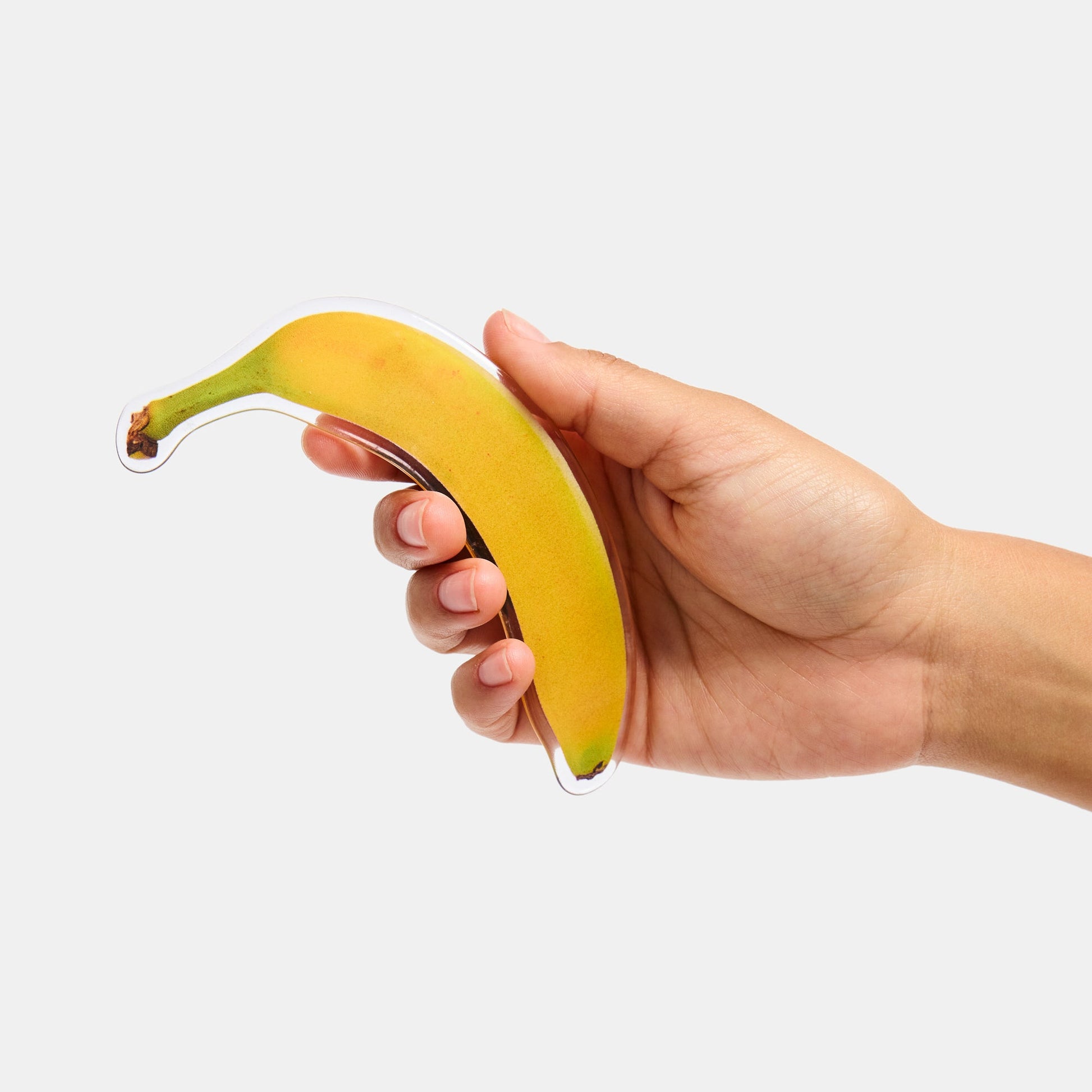 Hand holding hair barrette with printed banana design.