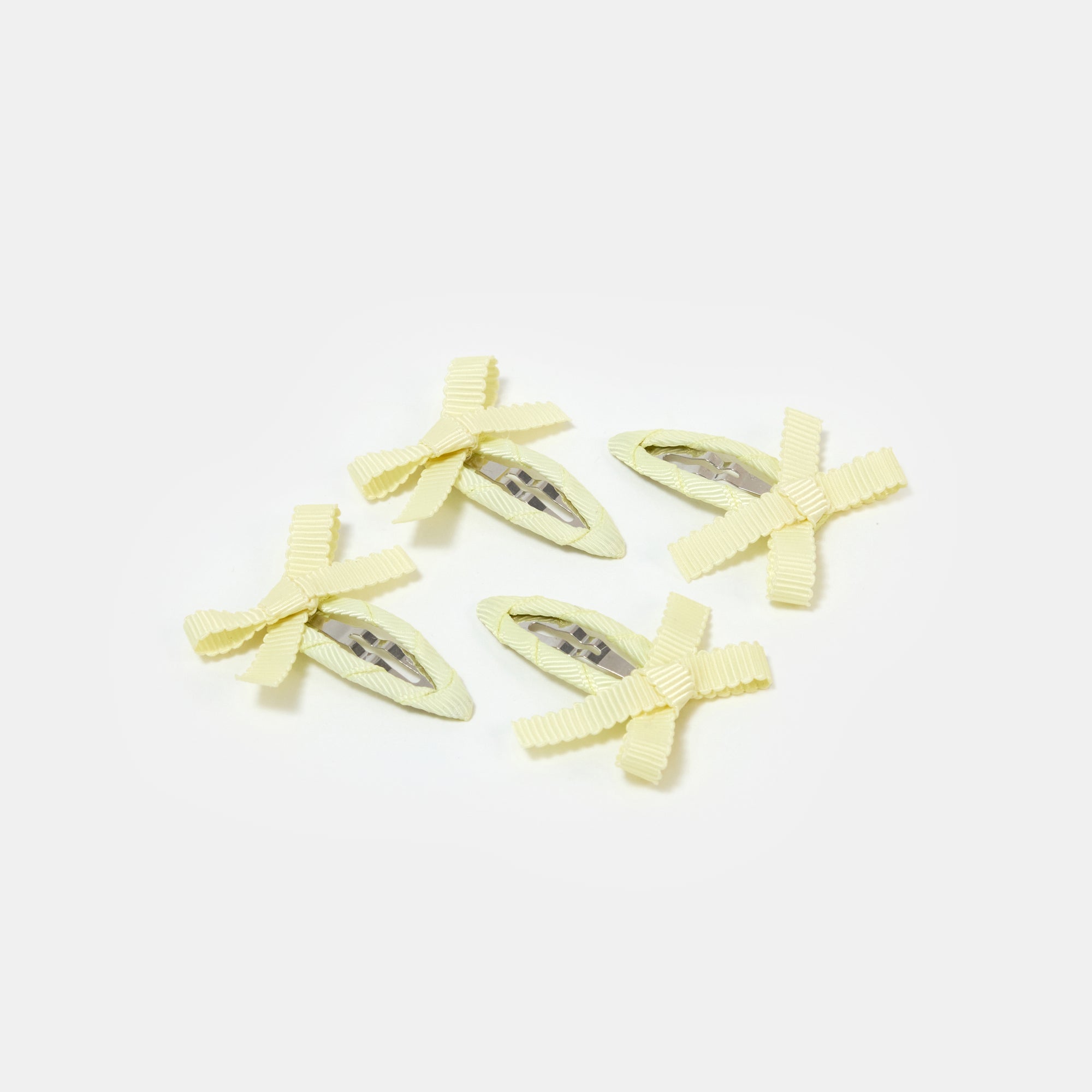 Four yellow snap clips with bows on a white background.