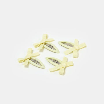 Four yellow snap clips with bows on a white background.