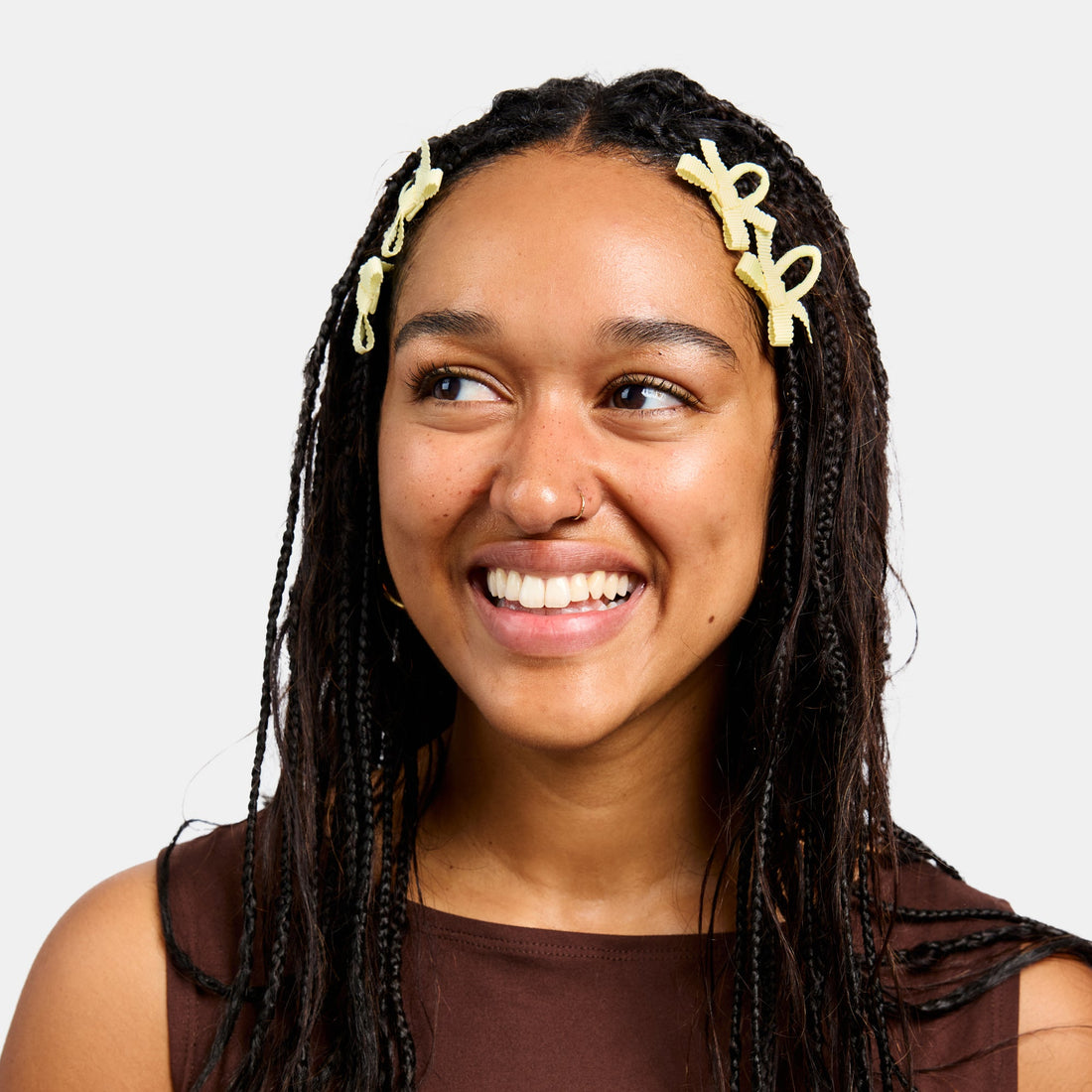 Four yellow snap clips with bows on a white background.