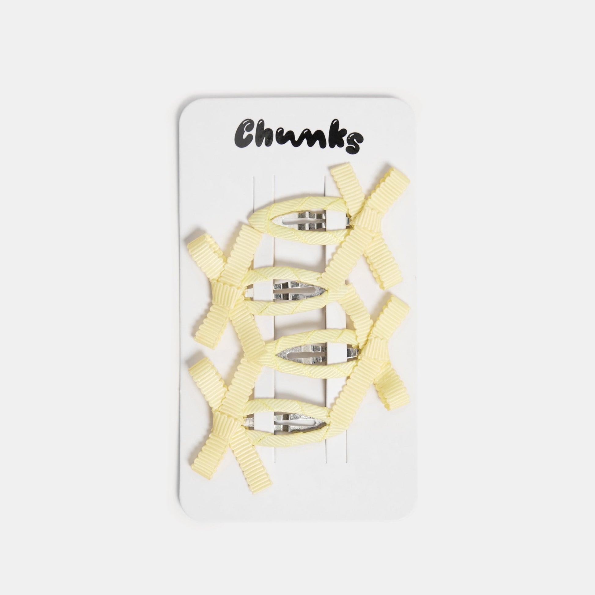 Four yellow snap clips with bows on a white packaging card