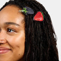 Woman wearing hair clasps with strawberry and blueberry print design.