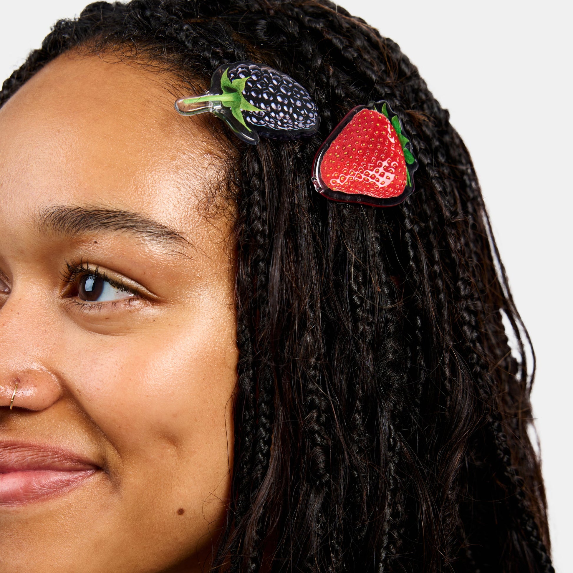 Woman wearing hair clasps with strawberry and blueberry print design.