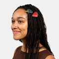 Woman with braids wearing two hair clasps with strawberry and blueberry prints.