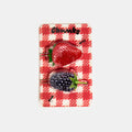 Hair clasp with strawberry and blueberry print design on a red packaging card