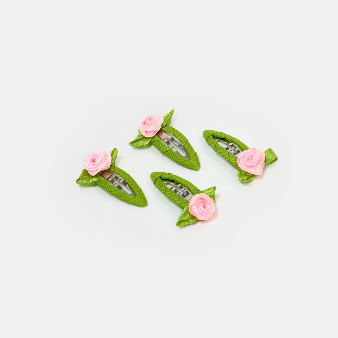 Four green and pink snap clips with rosette design on a white background.