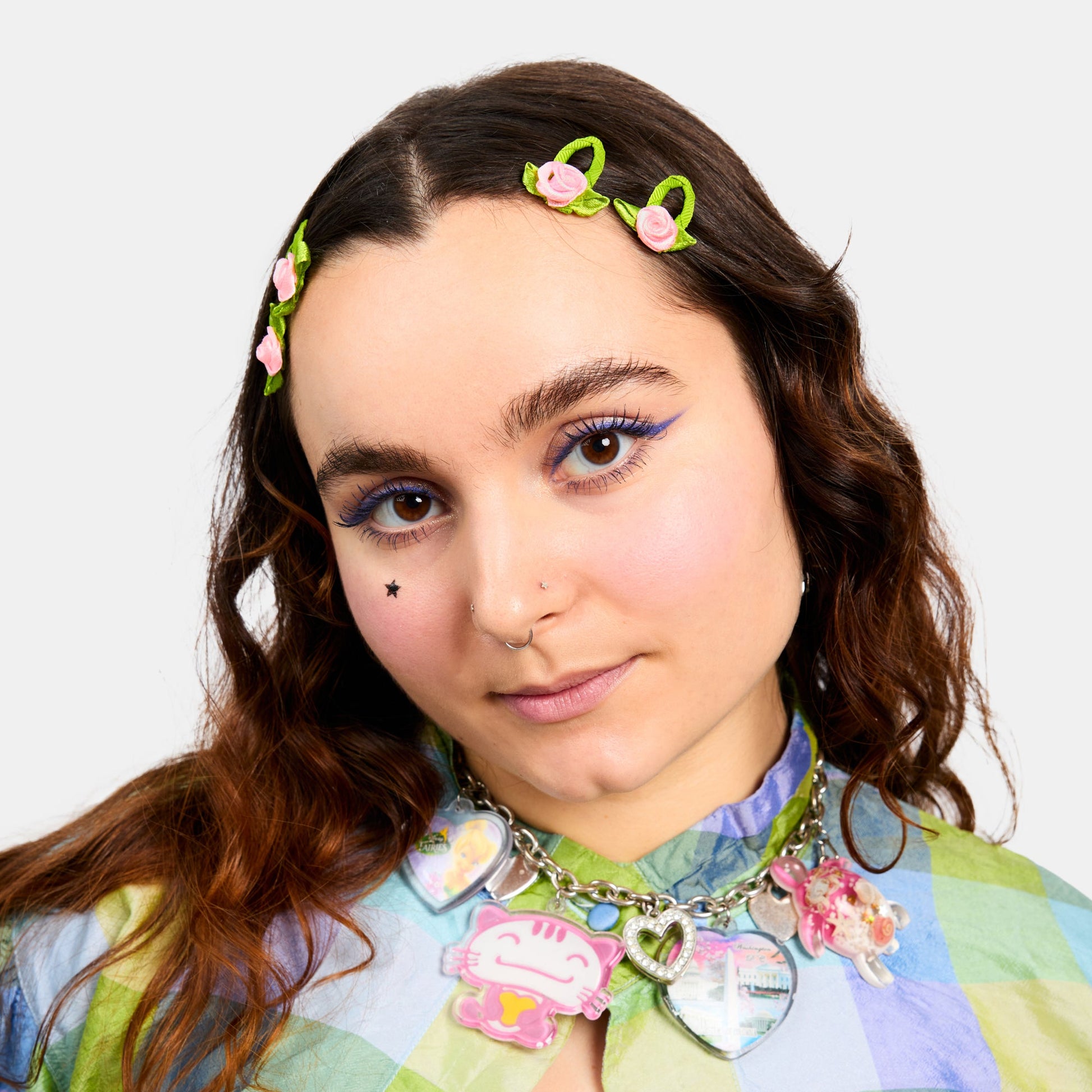 Woman wearing four green and pink snap clips with rosette design.
