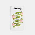 Four green and pink snap clips with rosette design on a white packaging card
