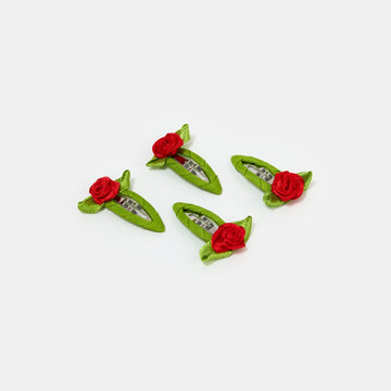 Four red and green snap clips with rosette design on a white background.