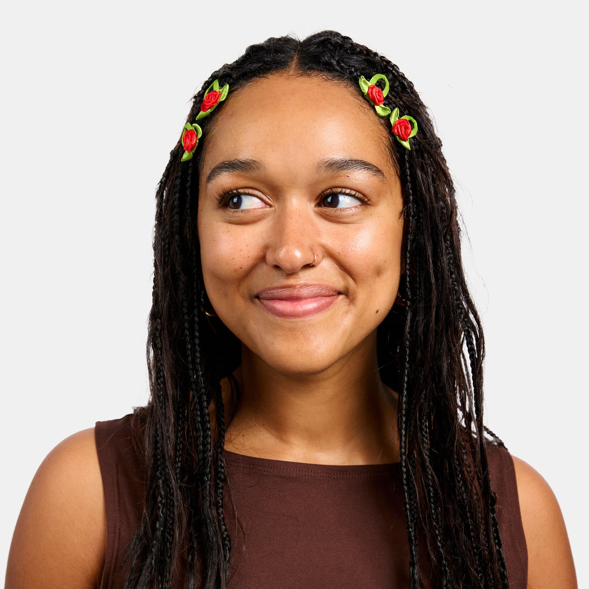 Woman with black braids wearing four red and green snap clips with rosette design