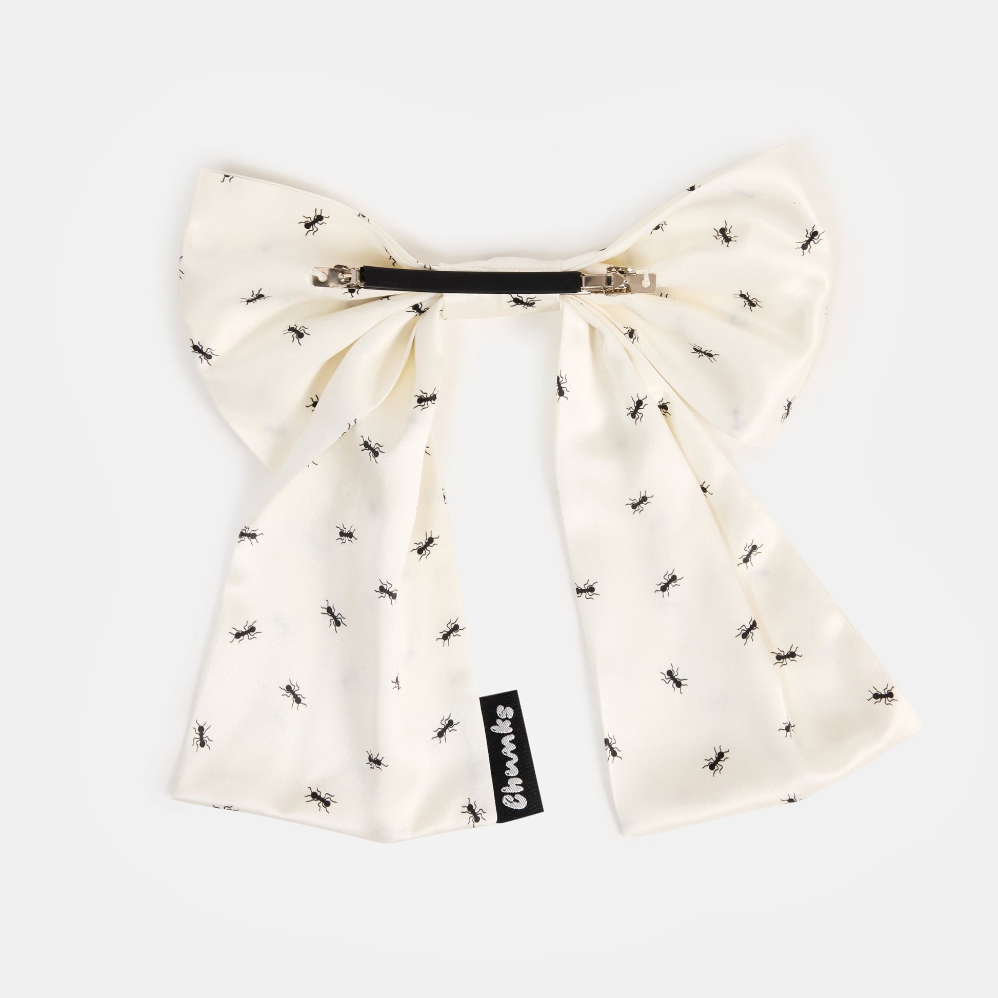 White silk bow barrette with printed ants on a white background