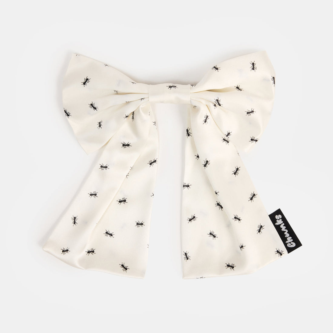 White silk bow barrette with printed ants on a white background