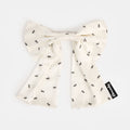 White silk bow barrette with printed ants on a white background