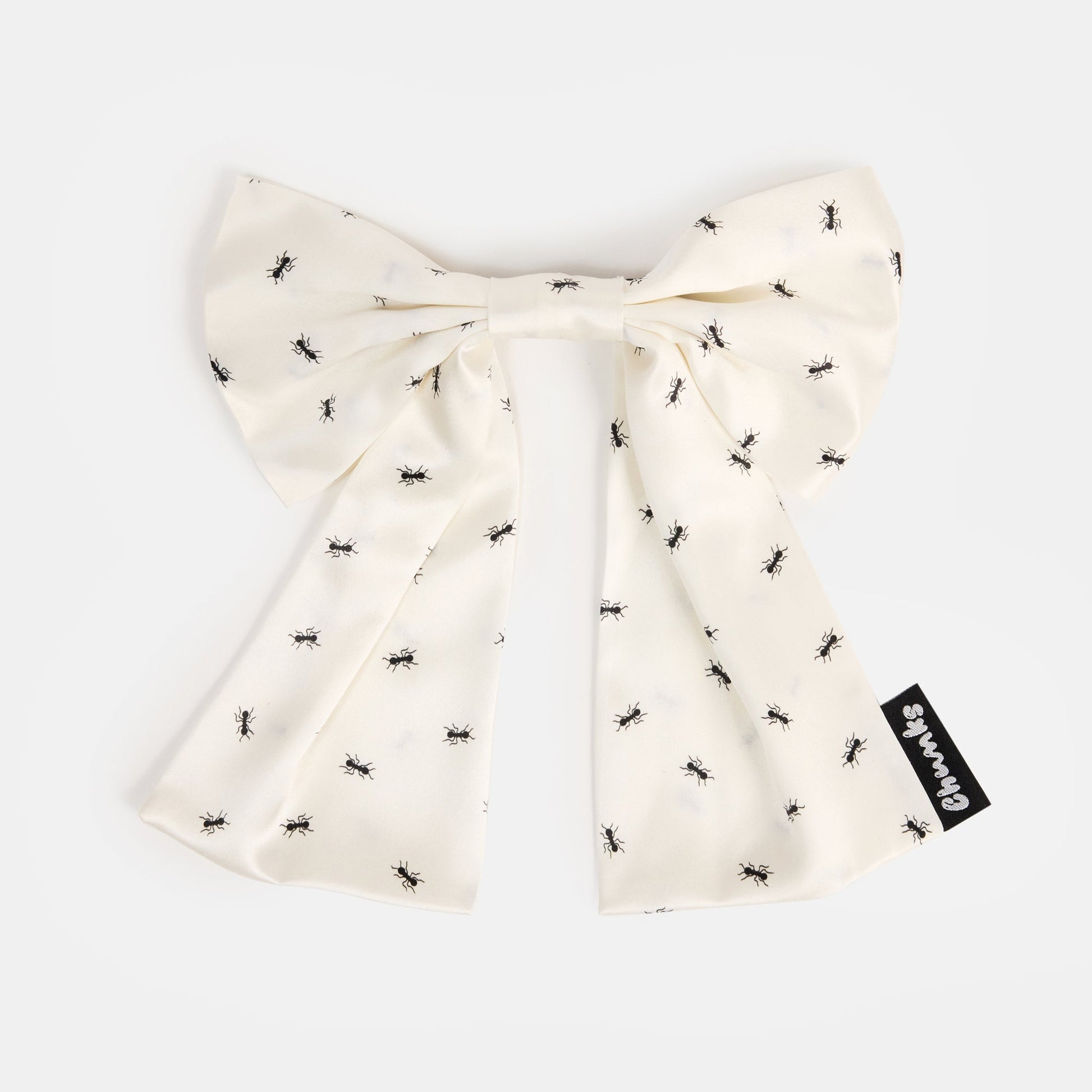 White silk bow barrette with printed ants on a white background